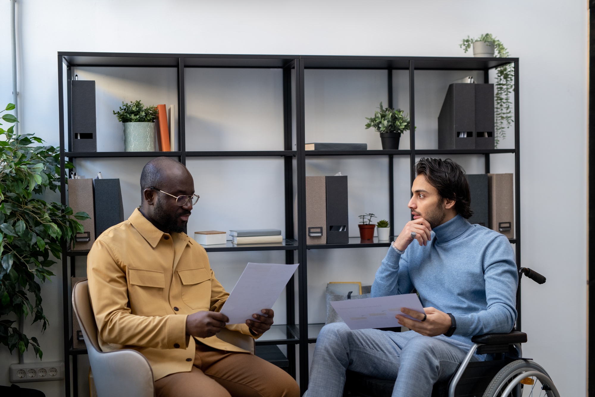 Small multi-ethnic group of businessmen with papers having discussion